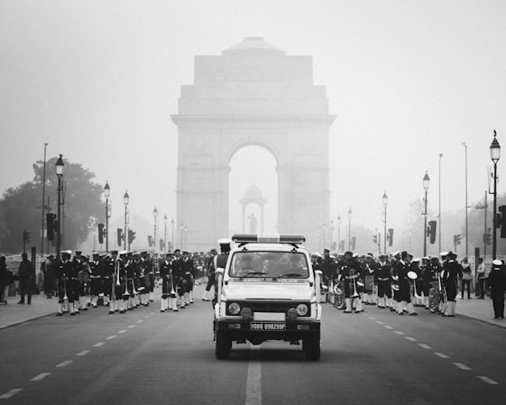 A black and white photo of a car driving down a street