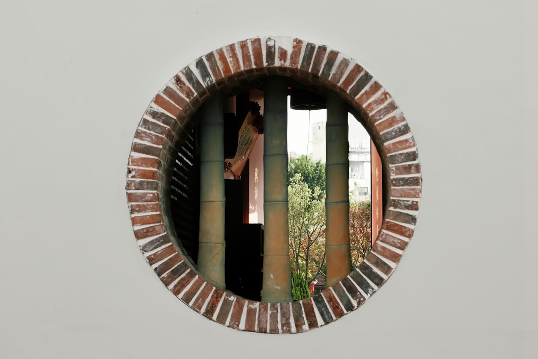 A round hole in a brick wall with a person in it,
