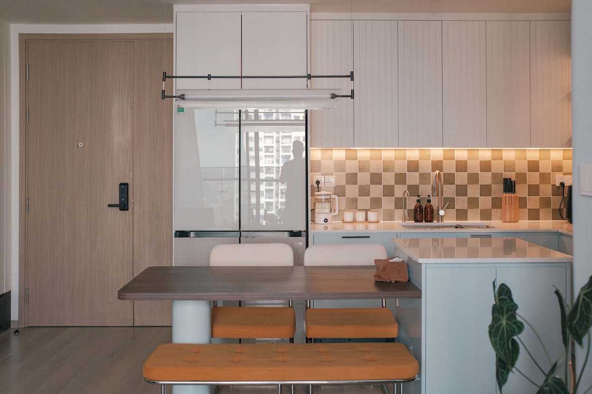 compact apartment kitchen with bar stools island and tiled backsplash