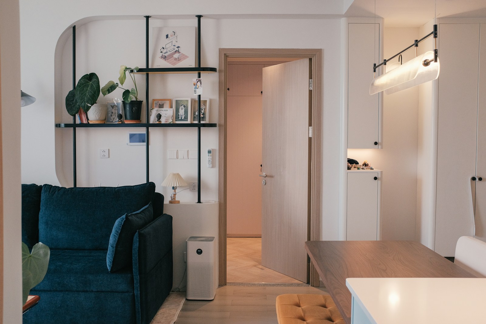 modern small apartment with blue velvet sofa shelving plants and air purifier