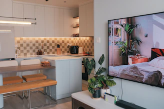 A flat screen TV mounted to a wall in a kitchen