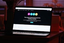A laptop computer sitting on top of a wooden desk
