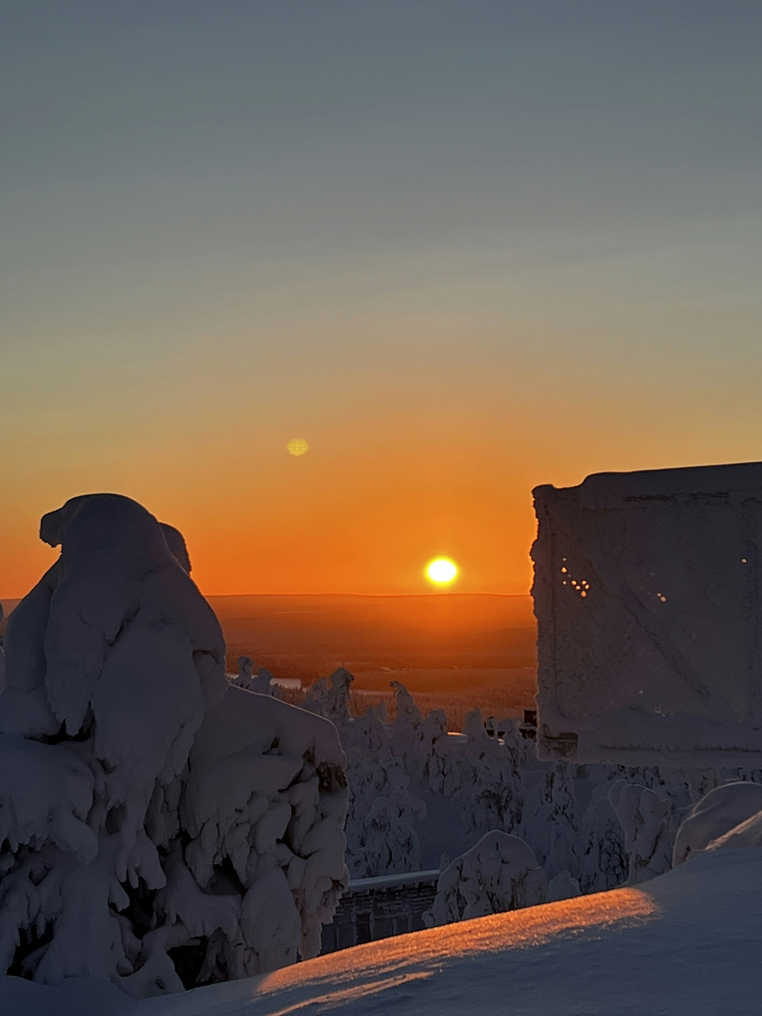 The sun is setting over a snowy landscape
