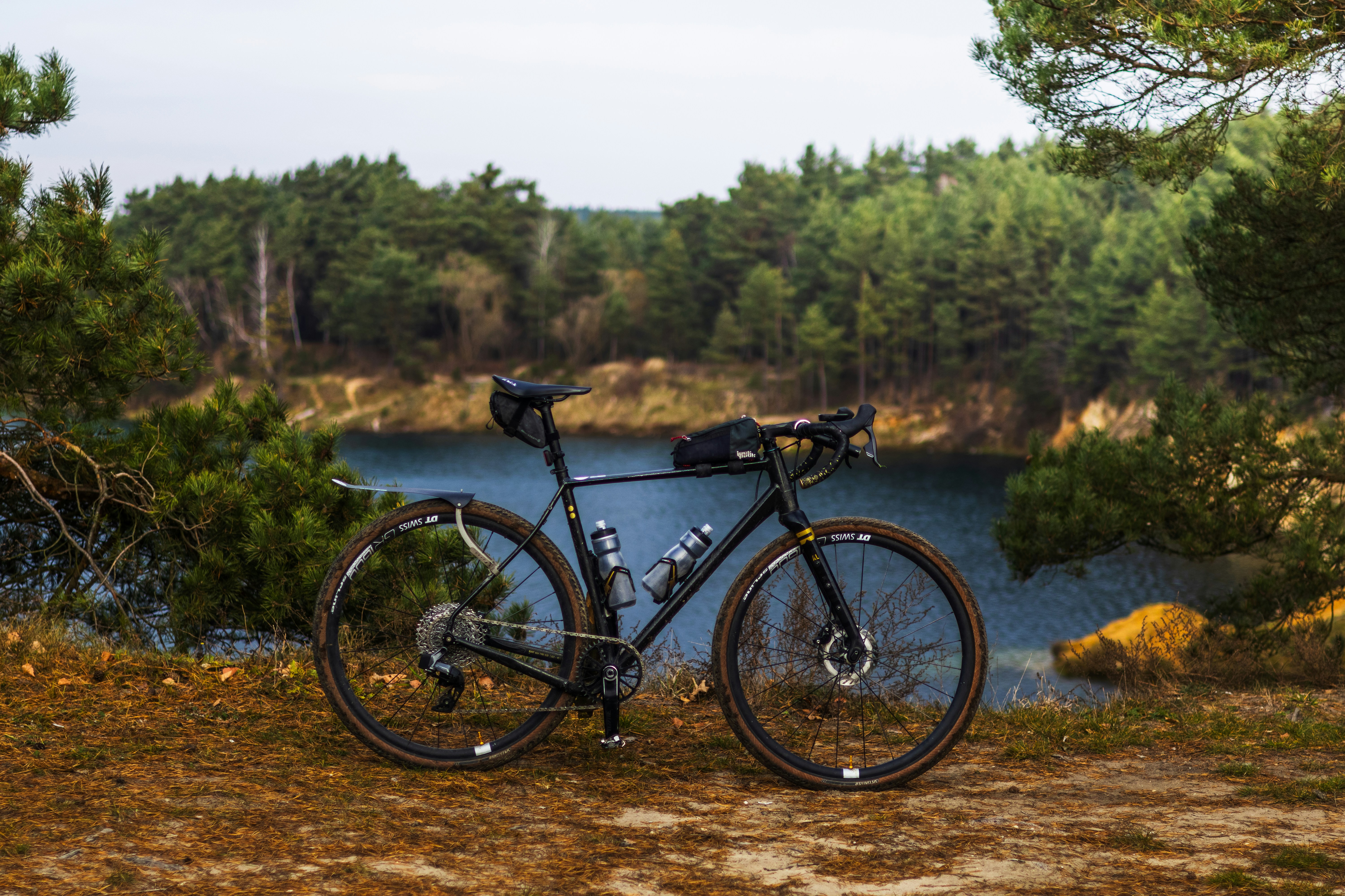 A bike parked on the side of a road next to a lake