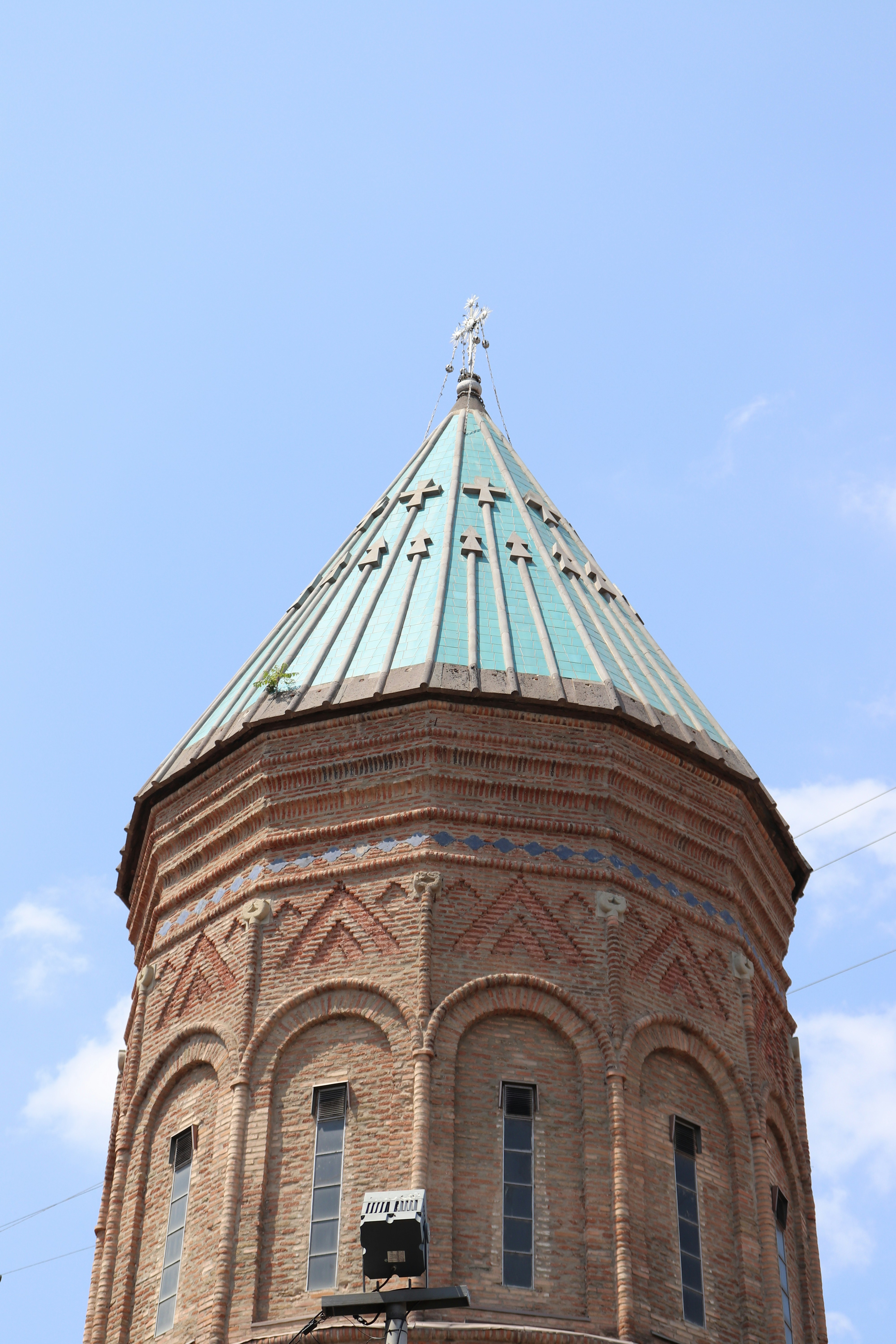 A tall brick tower with a cross on top