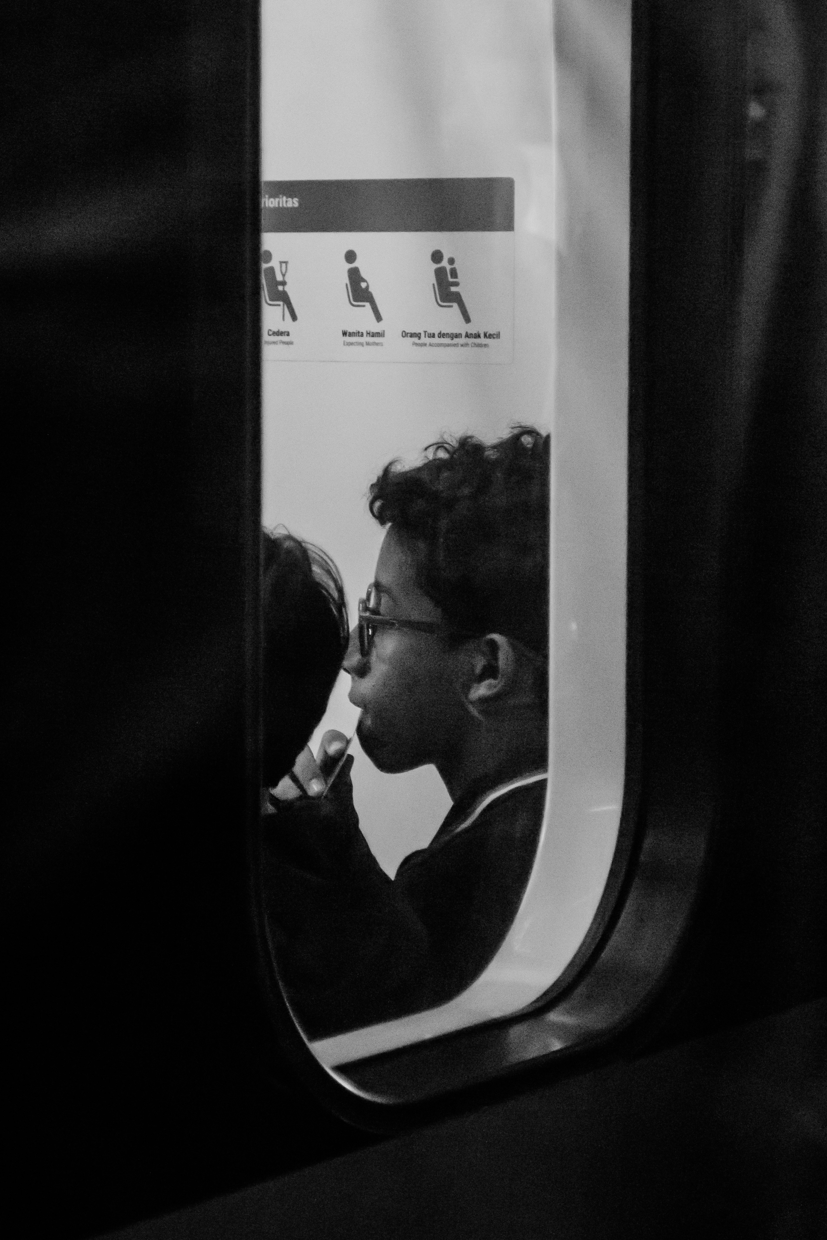 A black and white photo of a person on a train