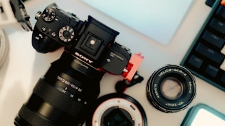 A camera sitting on top of a table next to a laptop