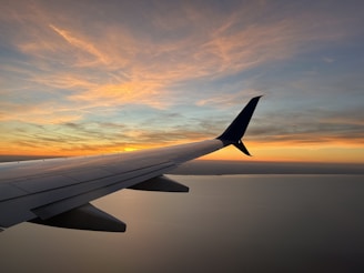 The wing of an airplane as the sun sets