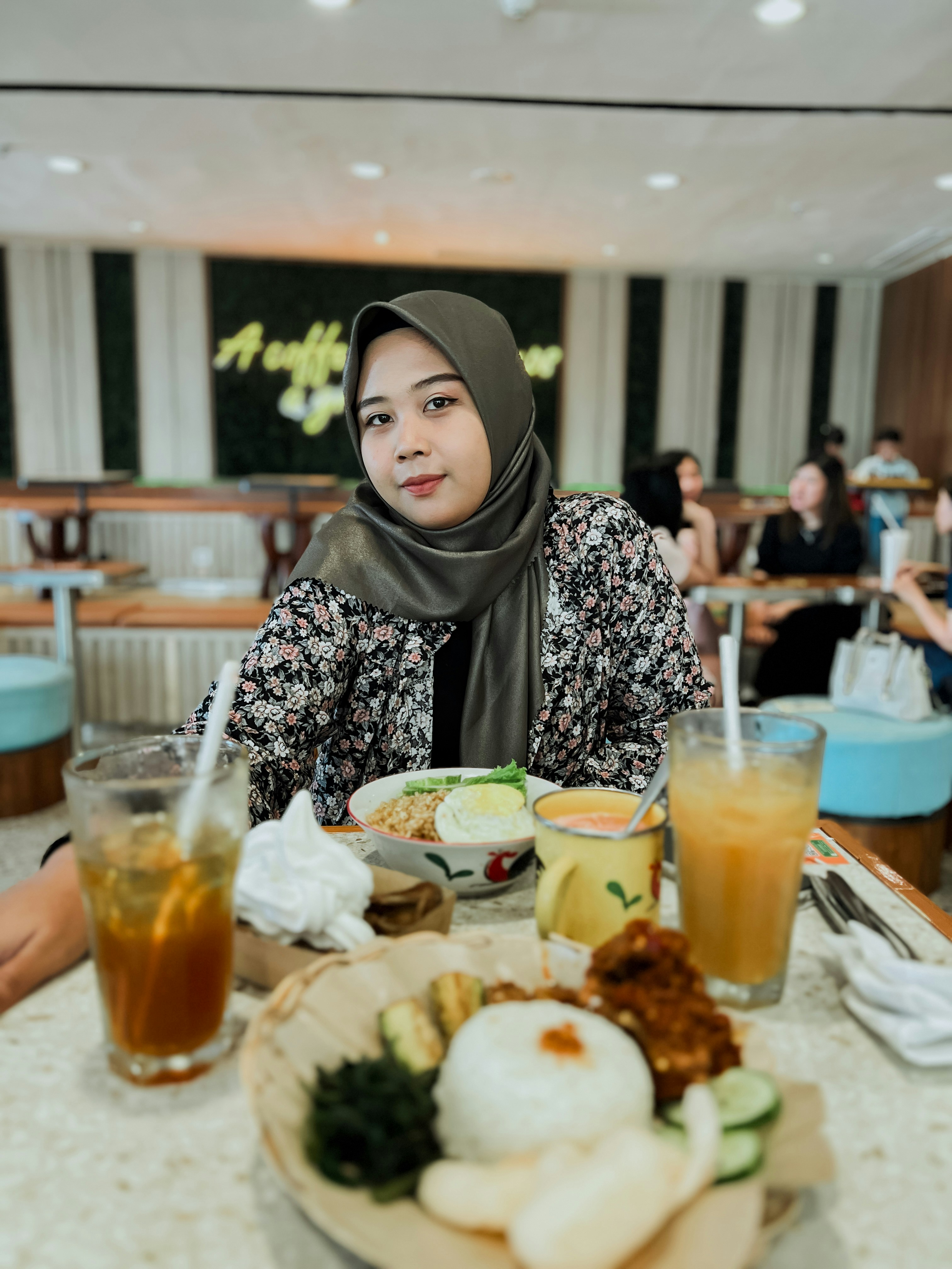 Seorang wanita duduk di meja dengan sepiring makanan