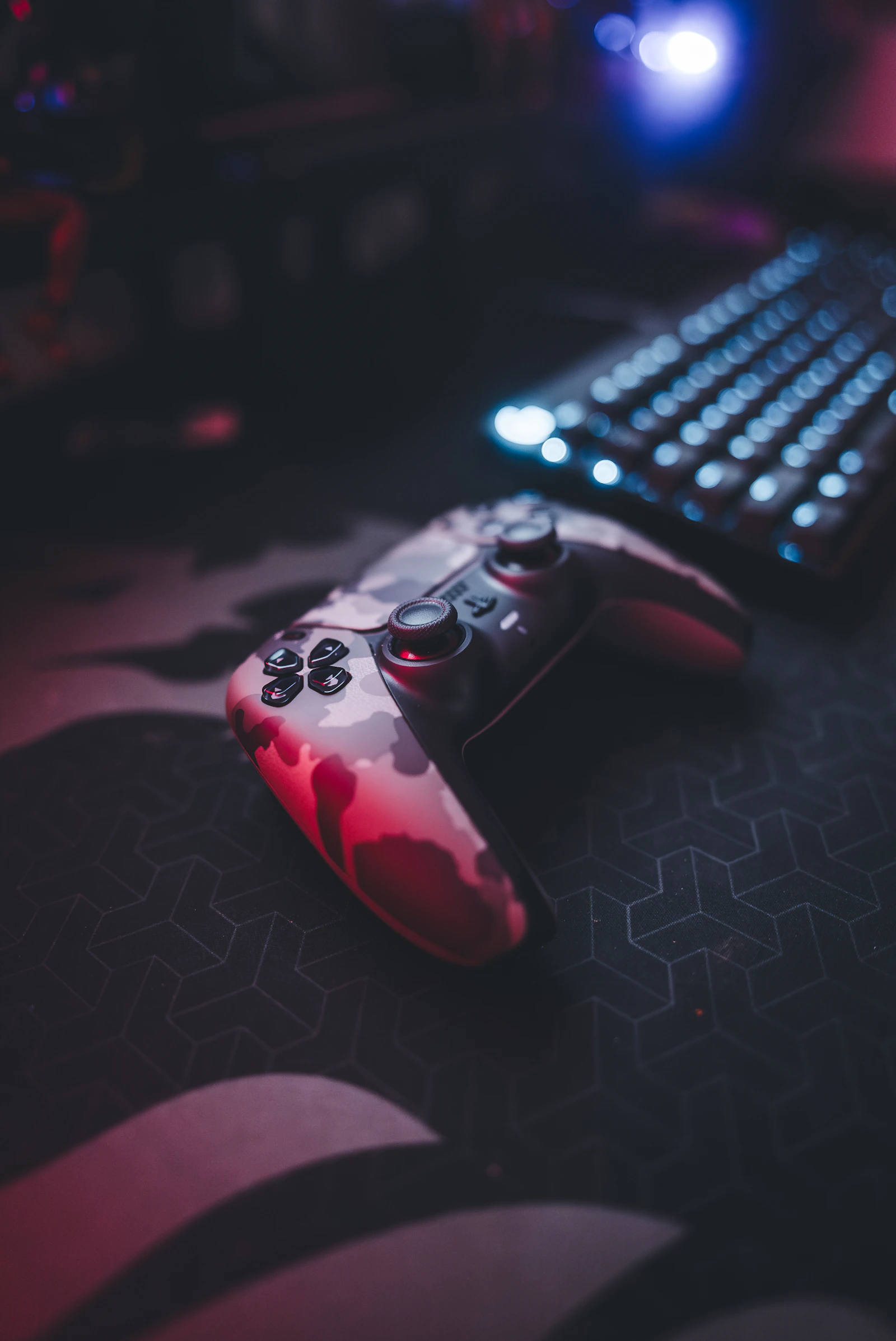 Gaming controller beside an illuminated mechanical keyboard