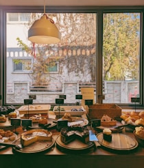 A table filled with lots of food next to a window