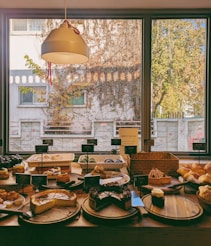 A table filled with lots of food next to a window