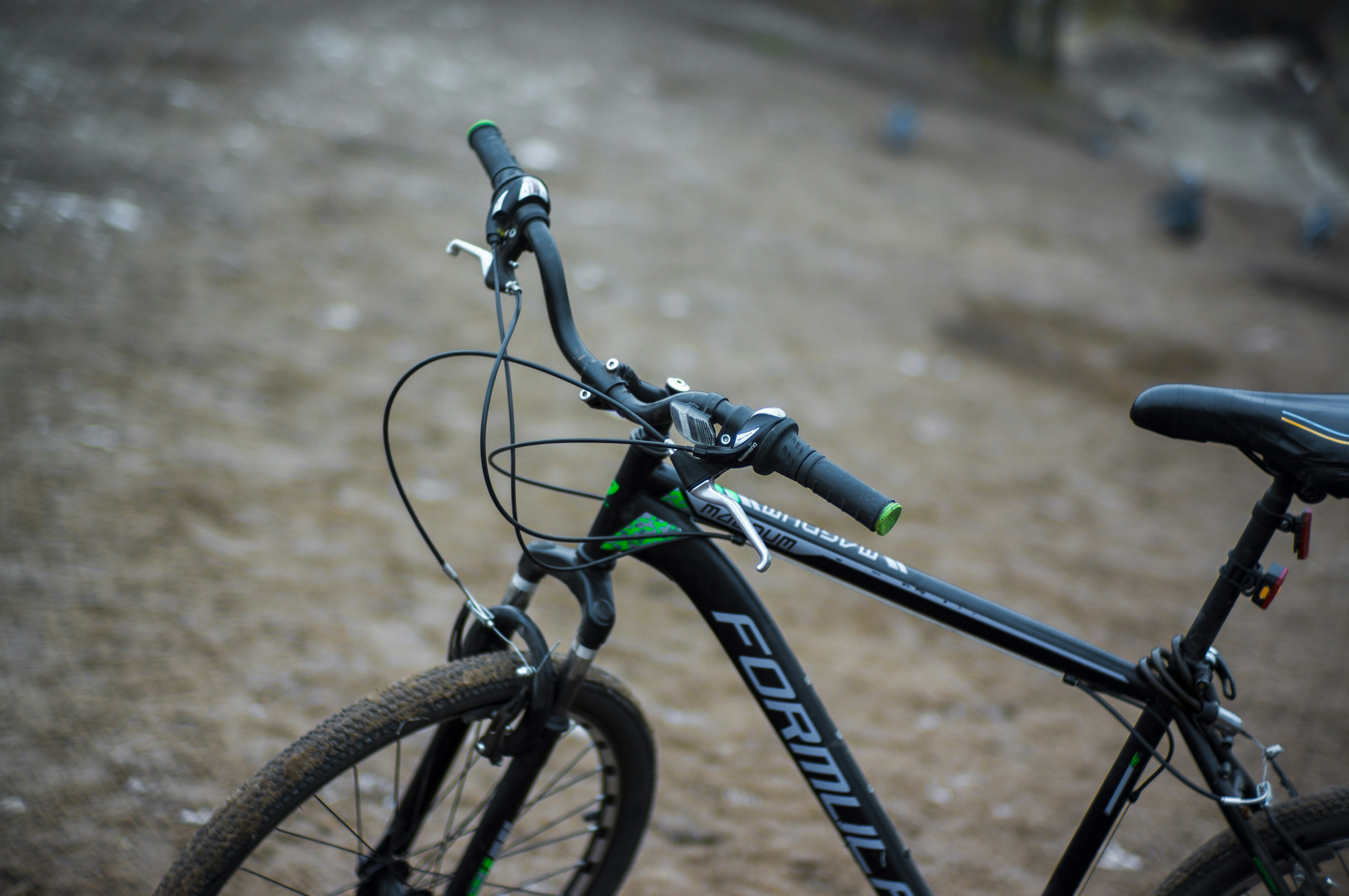 A black and green bike parked on a dirt road