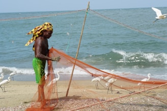 A man standing on a beach next to a net