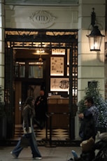 A man walking down a sidewalk next to a building
