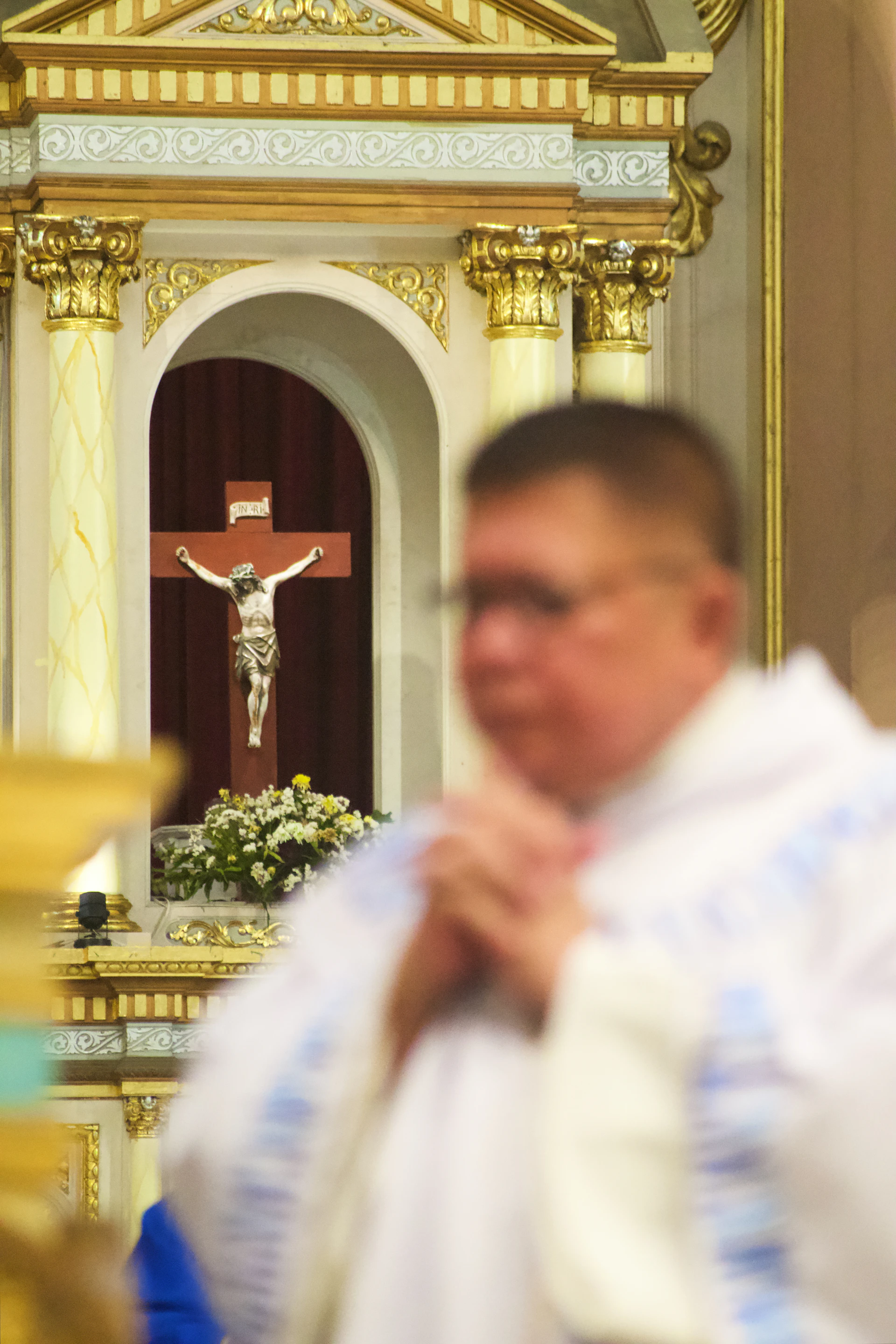 A man standing in front of a cross in a church