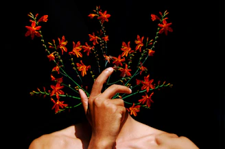 A man holding a bouquet of flowers in front of his face