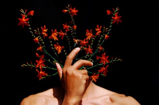 A man holding a bouquet of flowers in front of his face