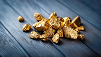 A pile of gold nuggets sitting on top of a wooden table