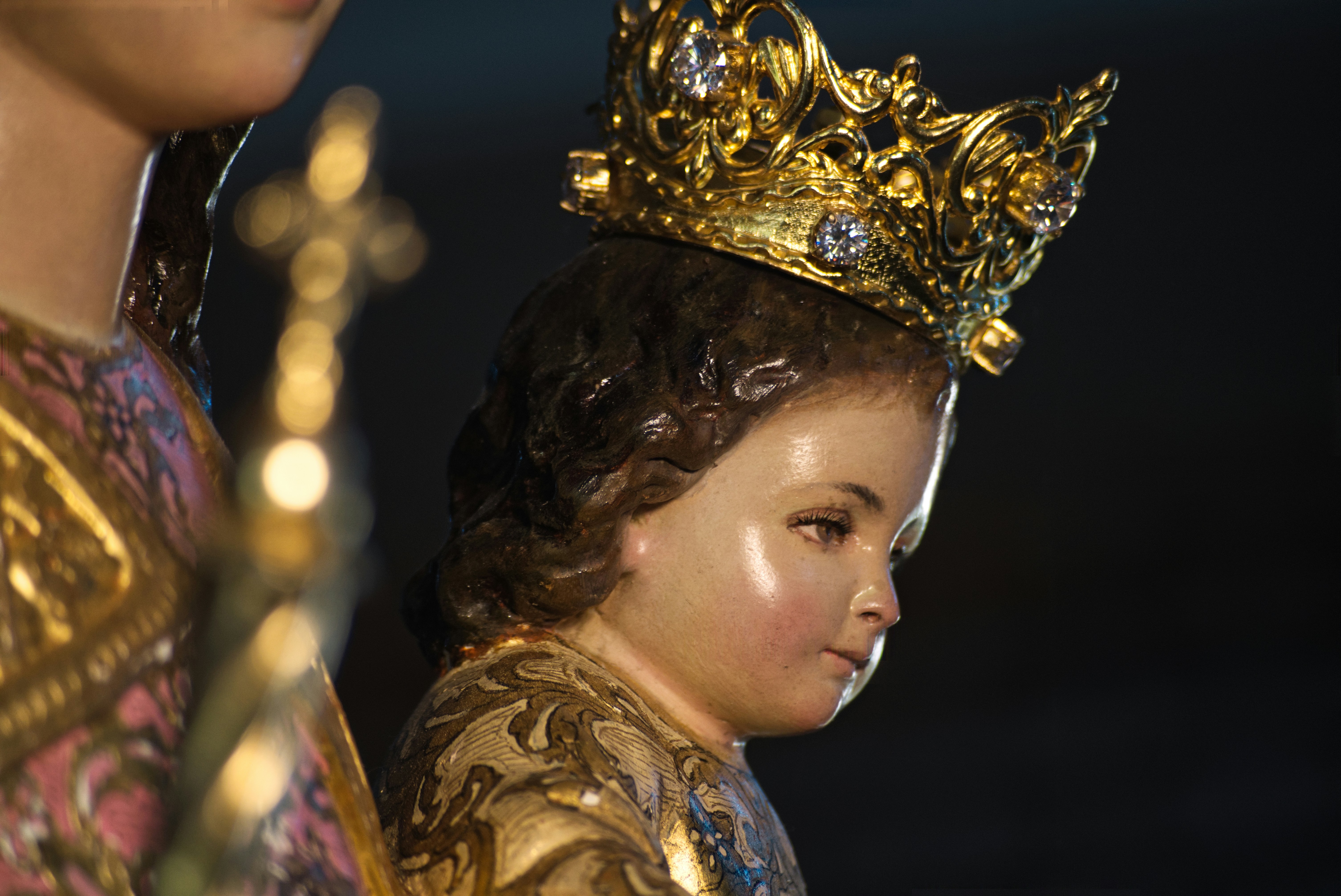 A close up of a statue of a child wearing a crown