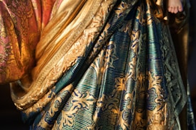 A close up of a woman wearing a gold and blue dress
