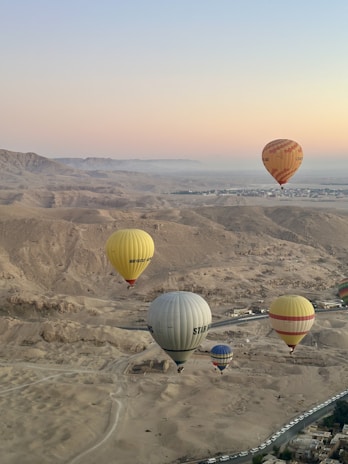 A group of hot air balloons flying over a desert