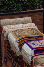 A pile of rugs sitting on top of a wooden bench
