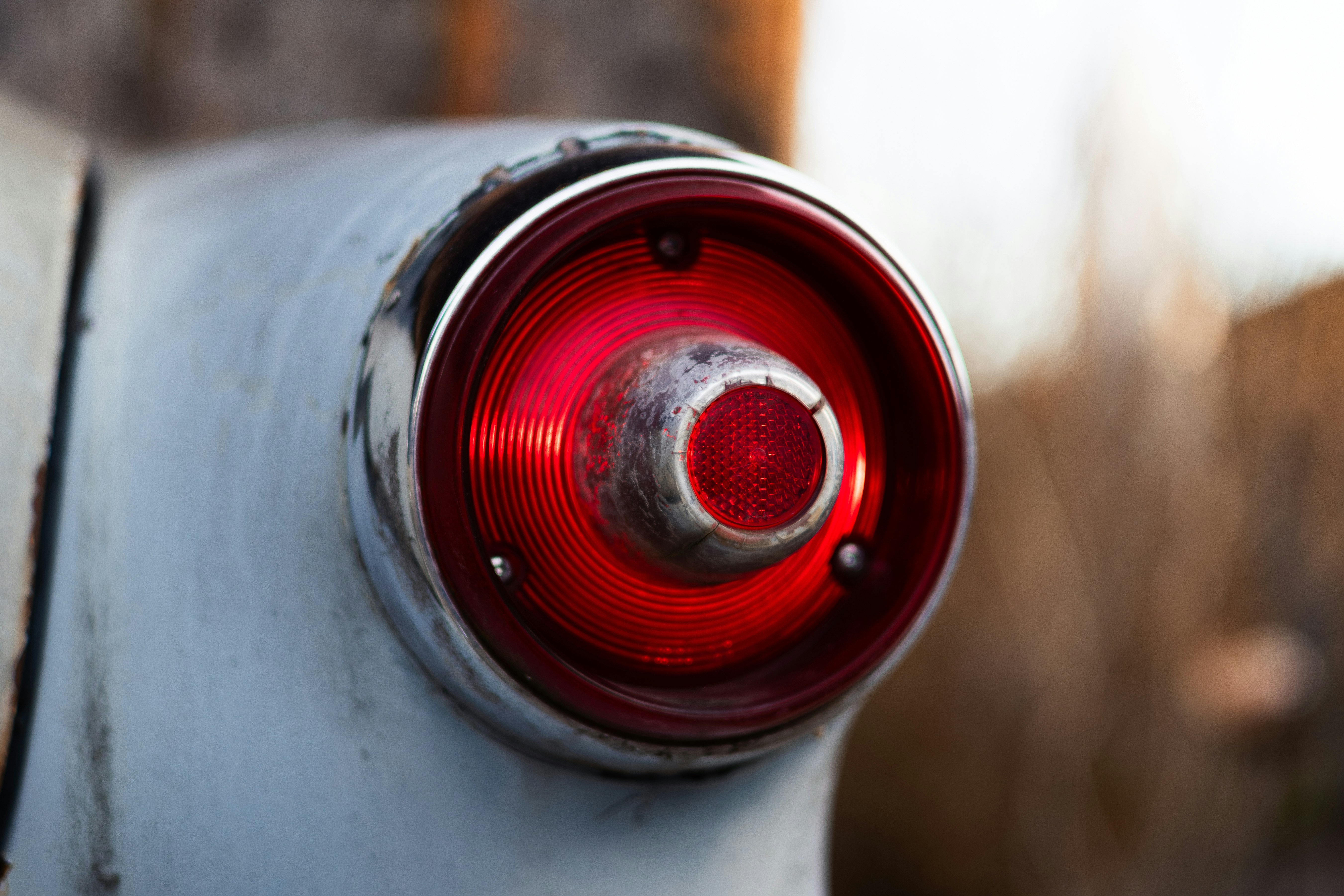 A close up of a red light on a white car