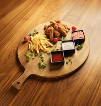 A wooden plate topped with french fries and ketchup