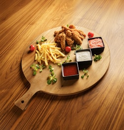 A wooden plate topped with french fries and ketchup