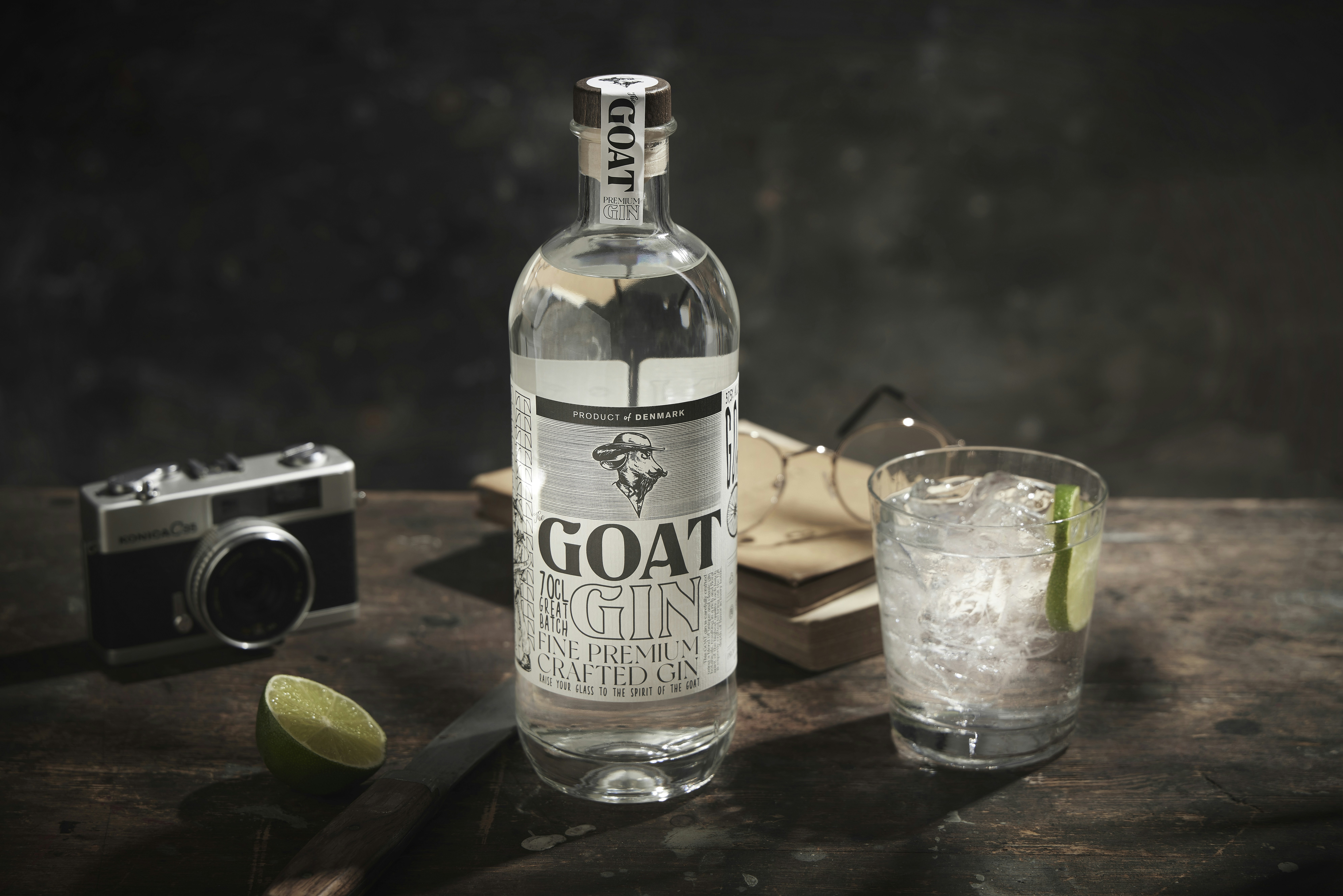 A bottle of goat gin next to a glass of gin