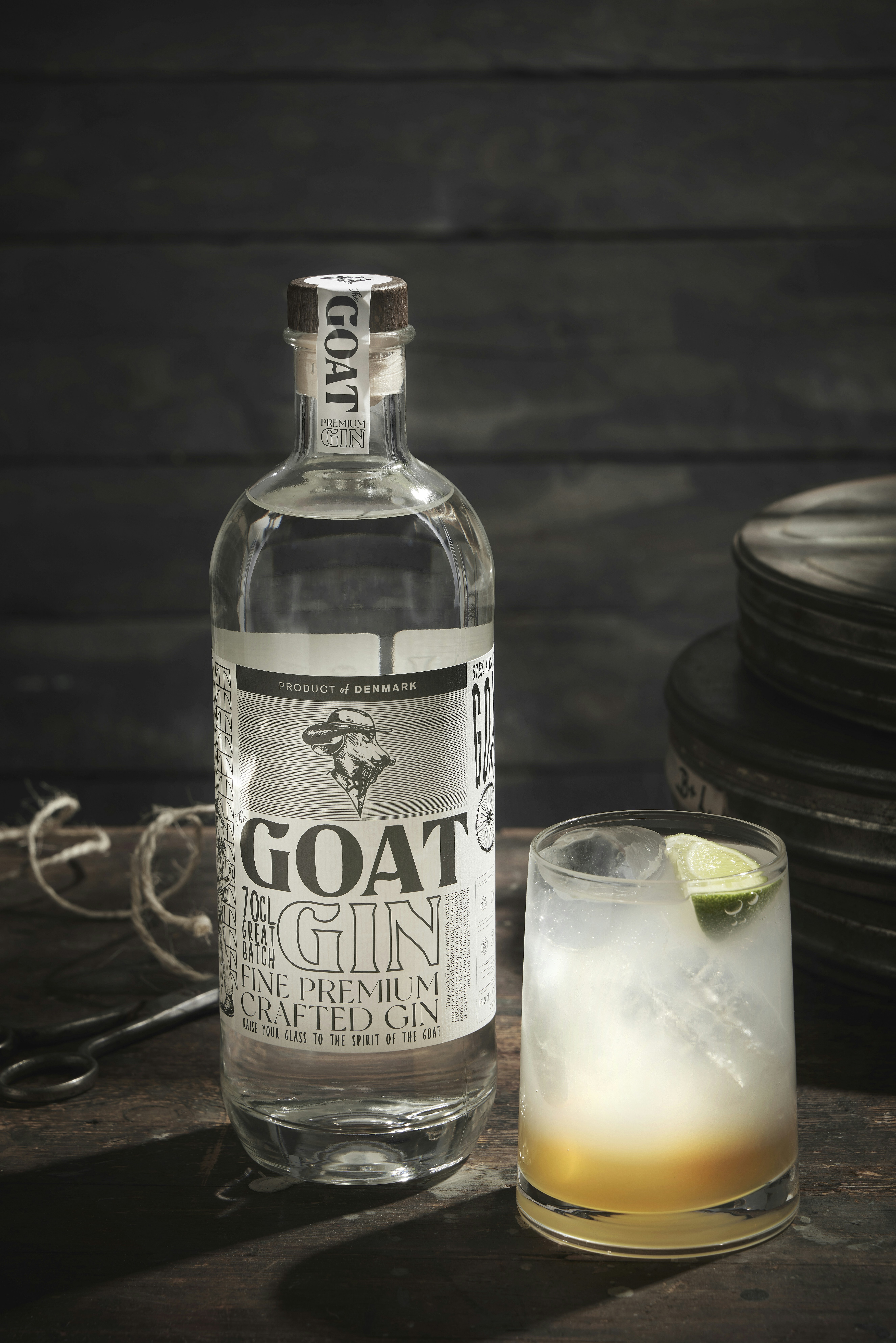 A bottle of goat gin next to a glass of gin