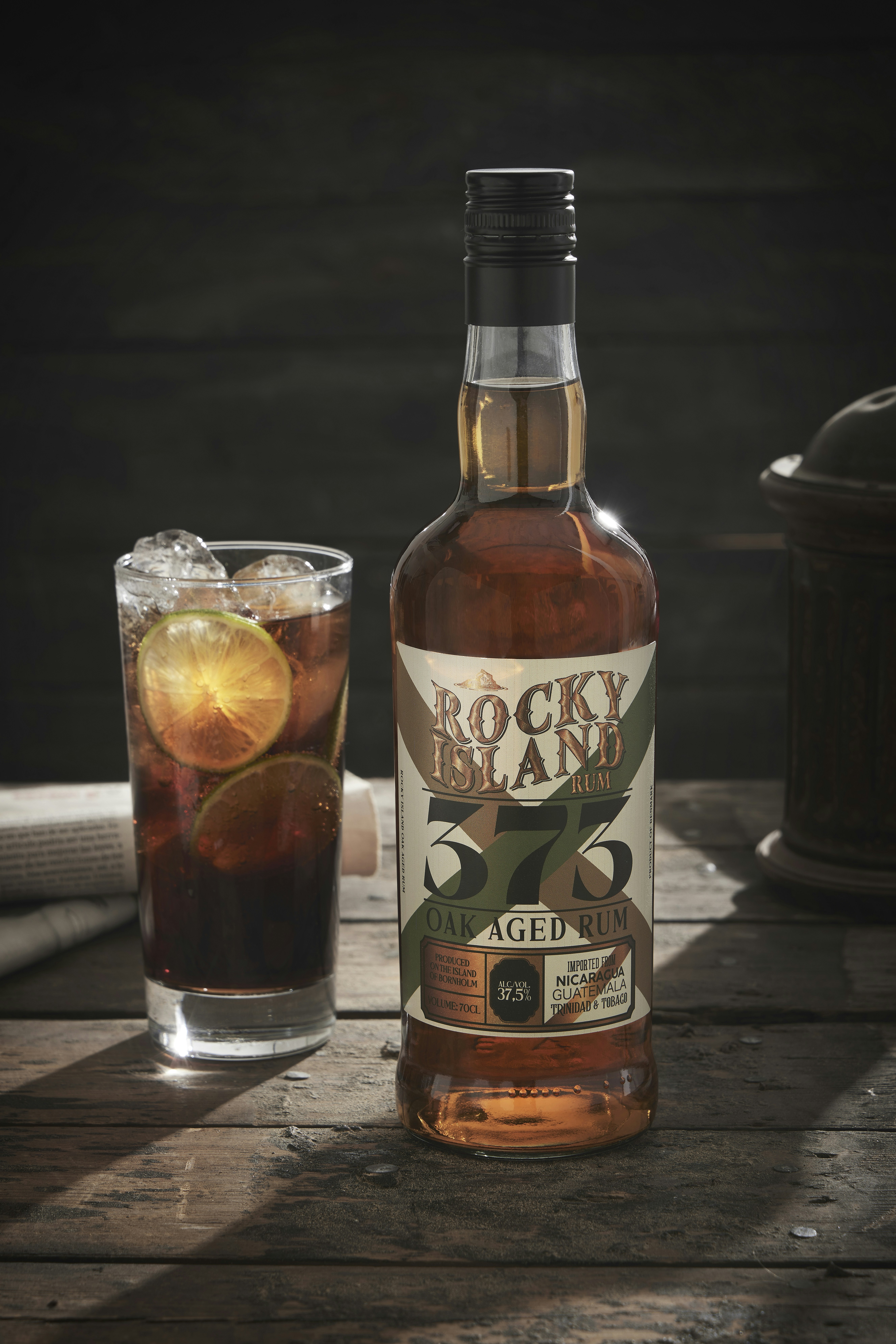 A bottle of whiskey next to a glass of ice tea