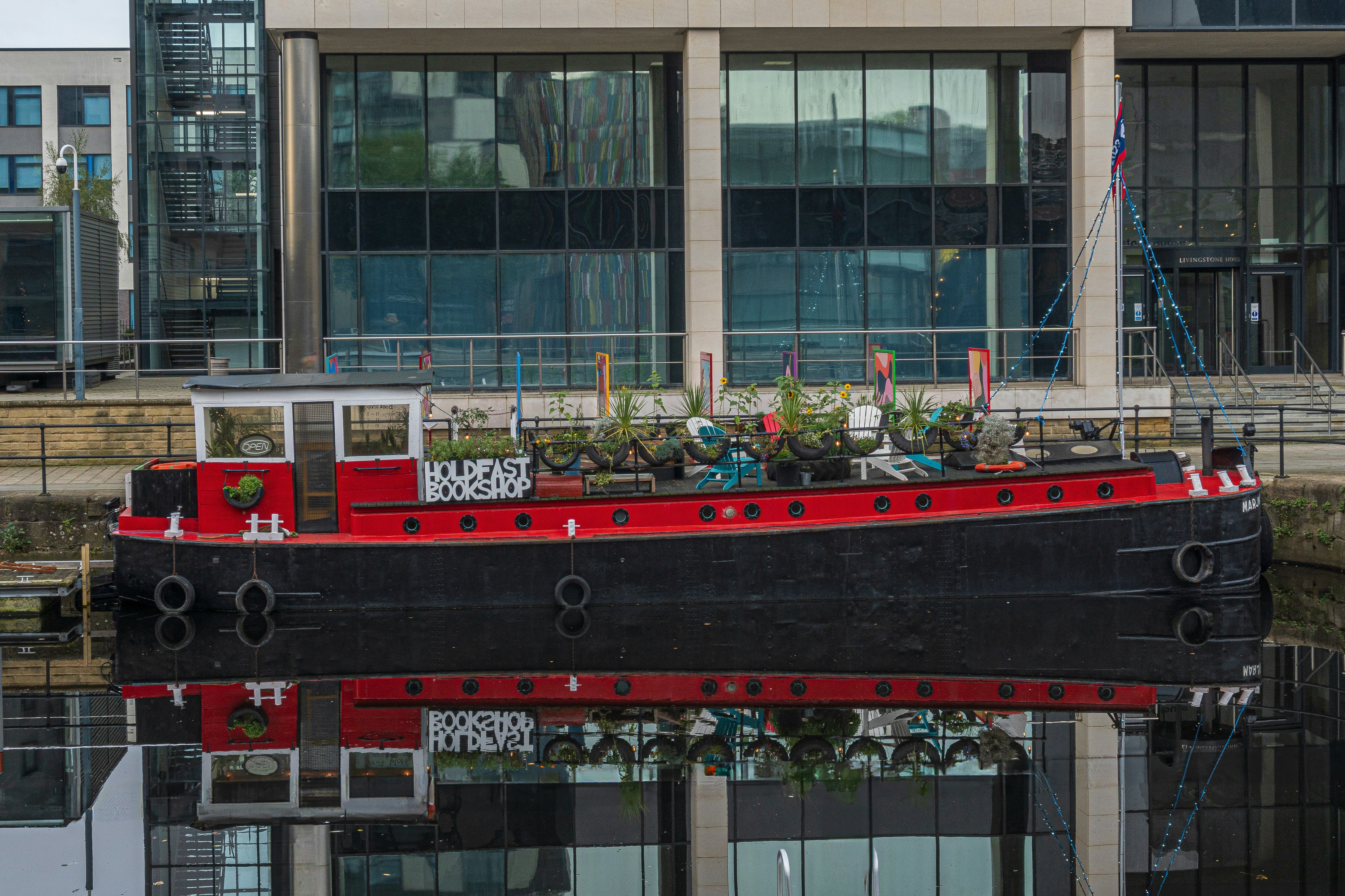 A red and black boat in front of a building photo – Free Leeds Image on ...