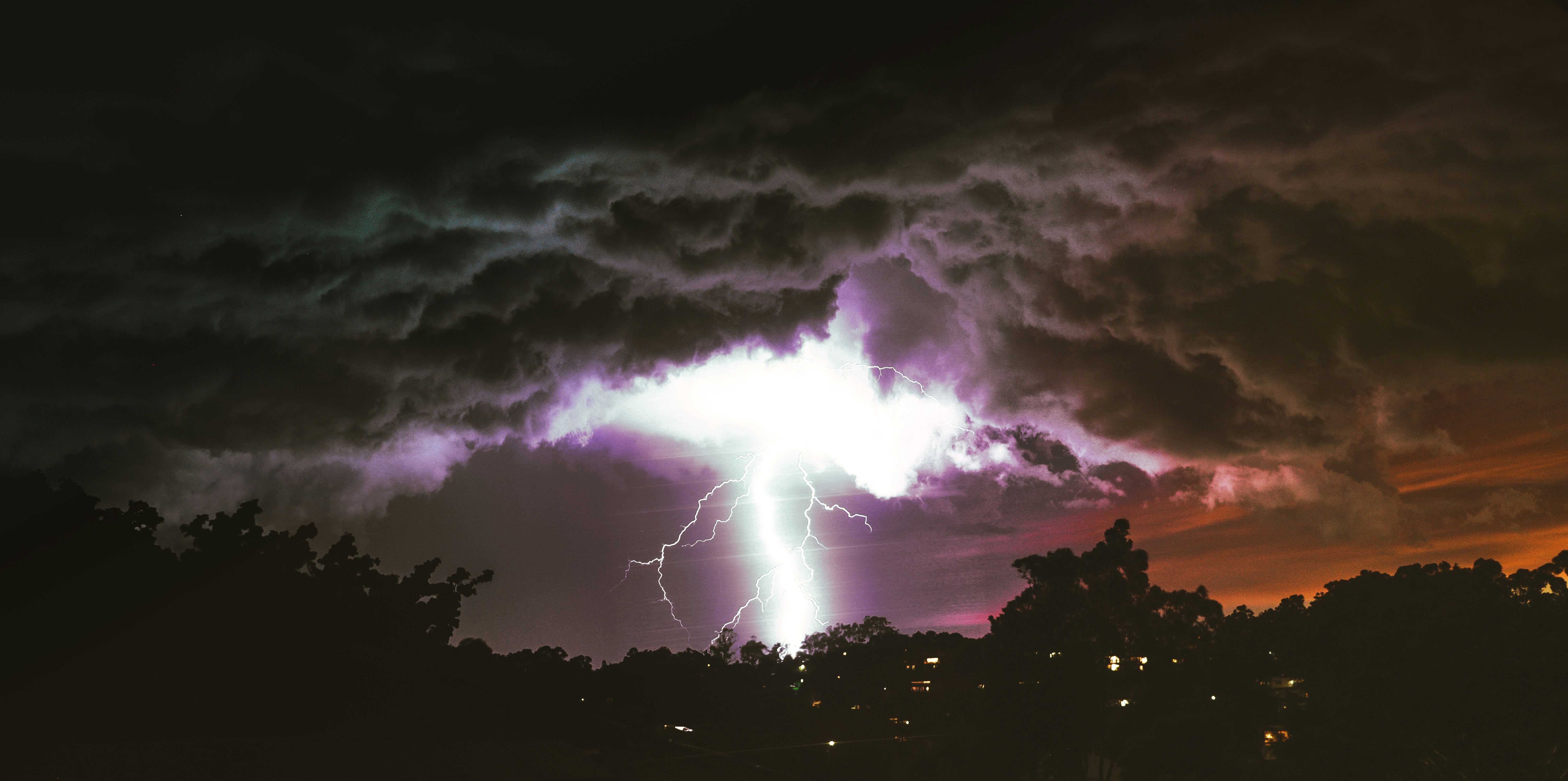 A lightning is seen in the sky over a city