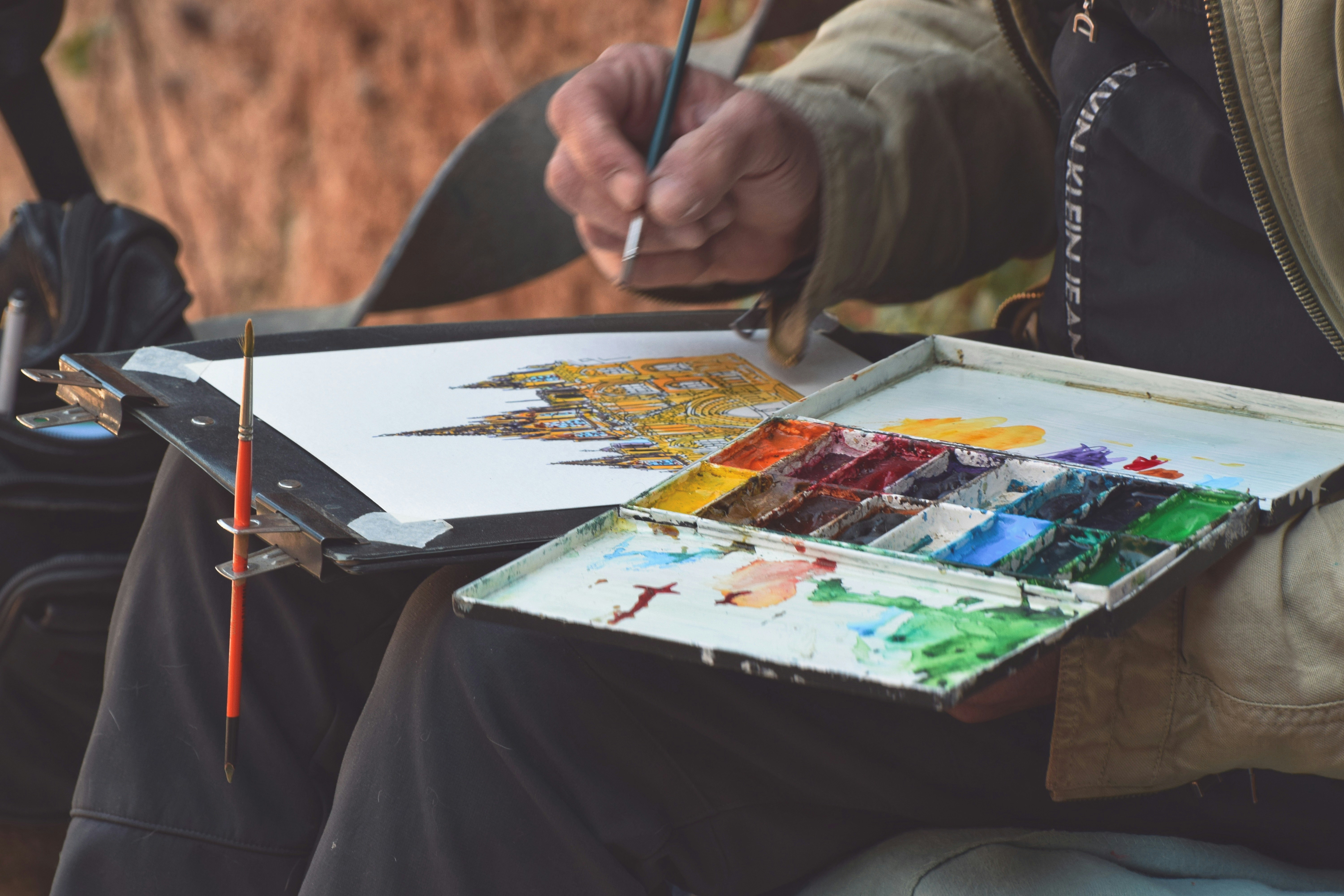 An artist thoughtfully painting a landscape, representing the focus of honing one's craft.
