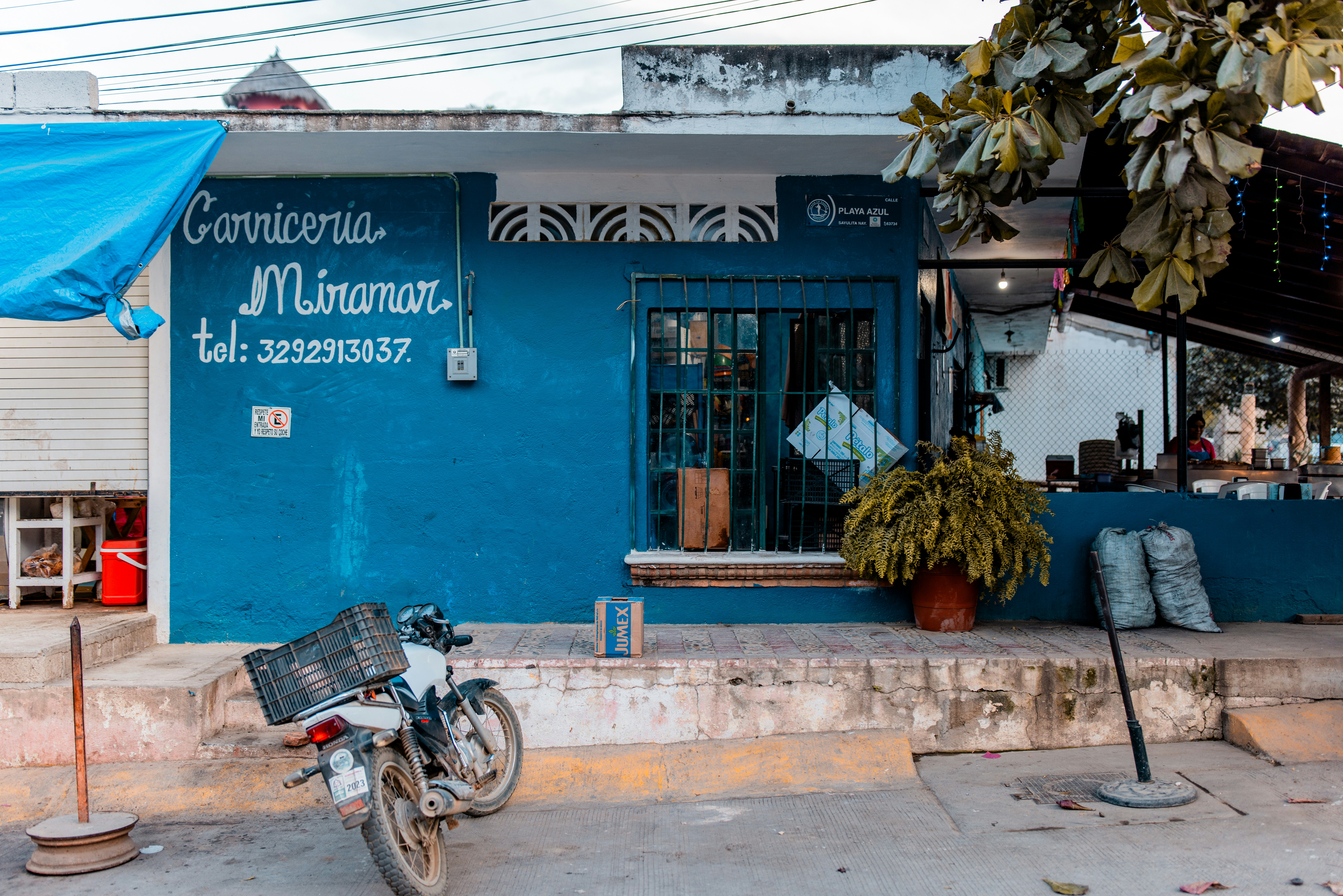 A motorcycle parked in front of a blue building