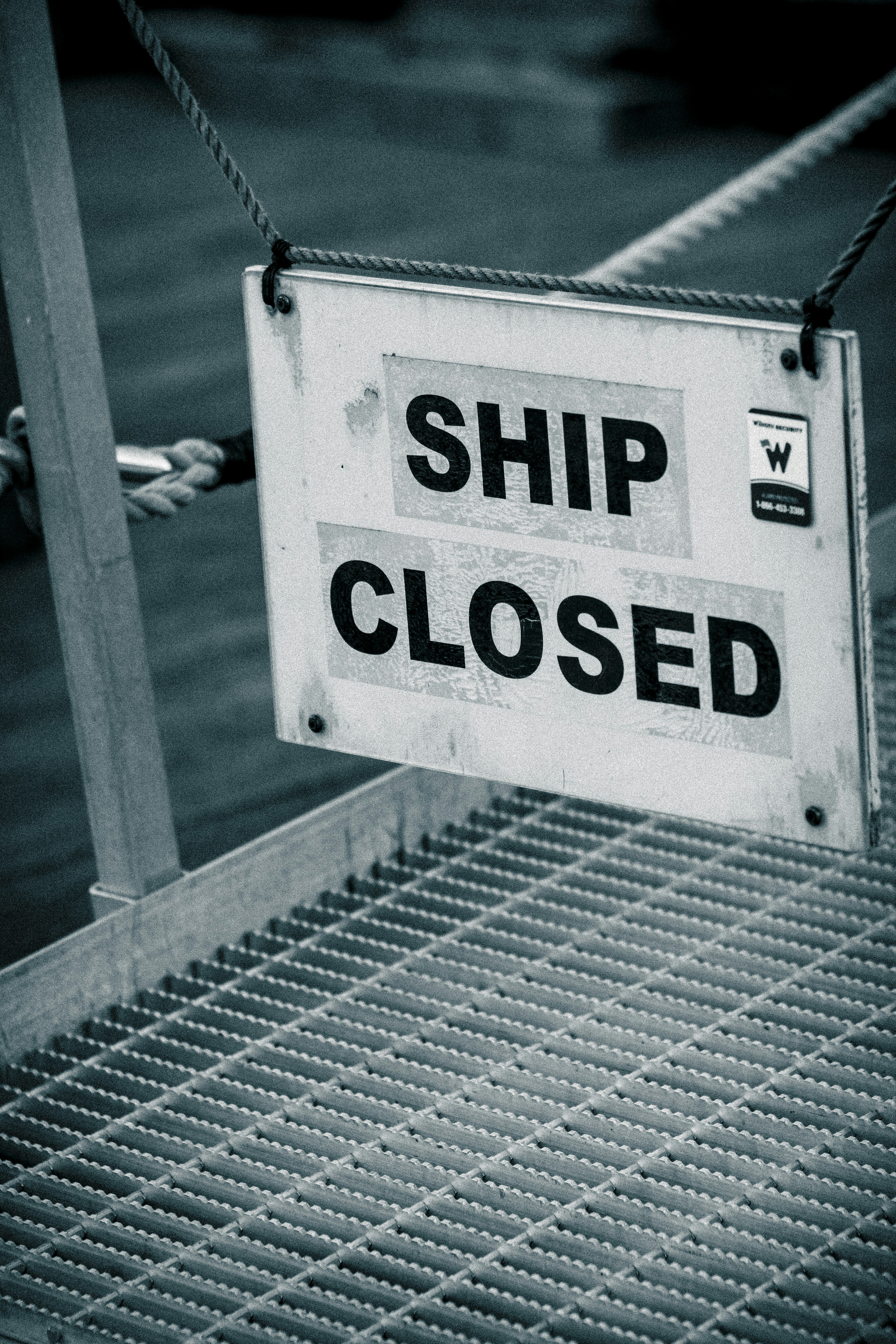 A sign that says ship closed hanging from a rope