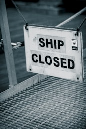 A sign that says ship closed hanging from a rope
