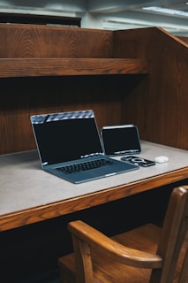 A laptop computer sitting on top of a wooden desk