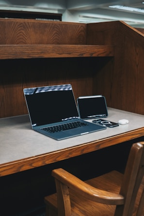 A laptop computer sitting on top of a wooden desk