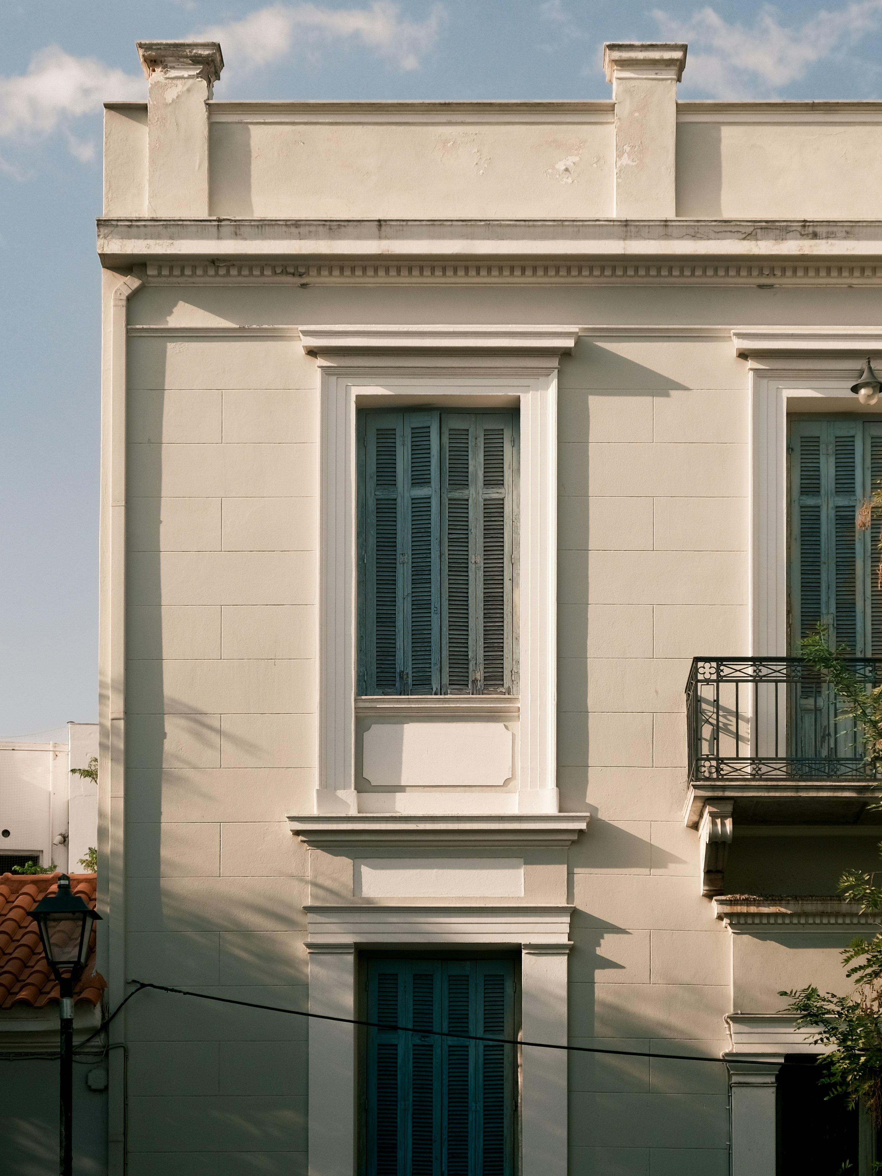 A tall white building with a blue door