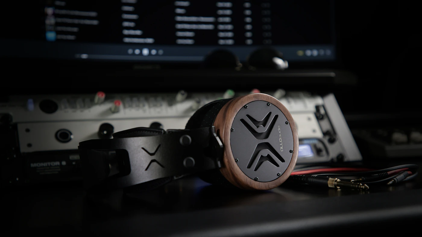 Studio headphones on a desk in front of an audio workstation