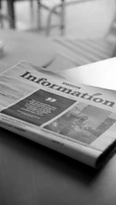 A newspaper sitting on top of a wooden table