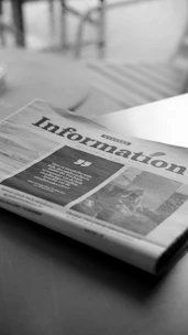 A newspaper sitting on top of a wooden table