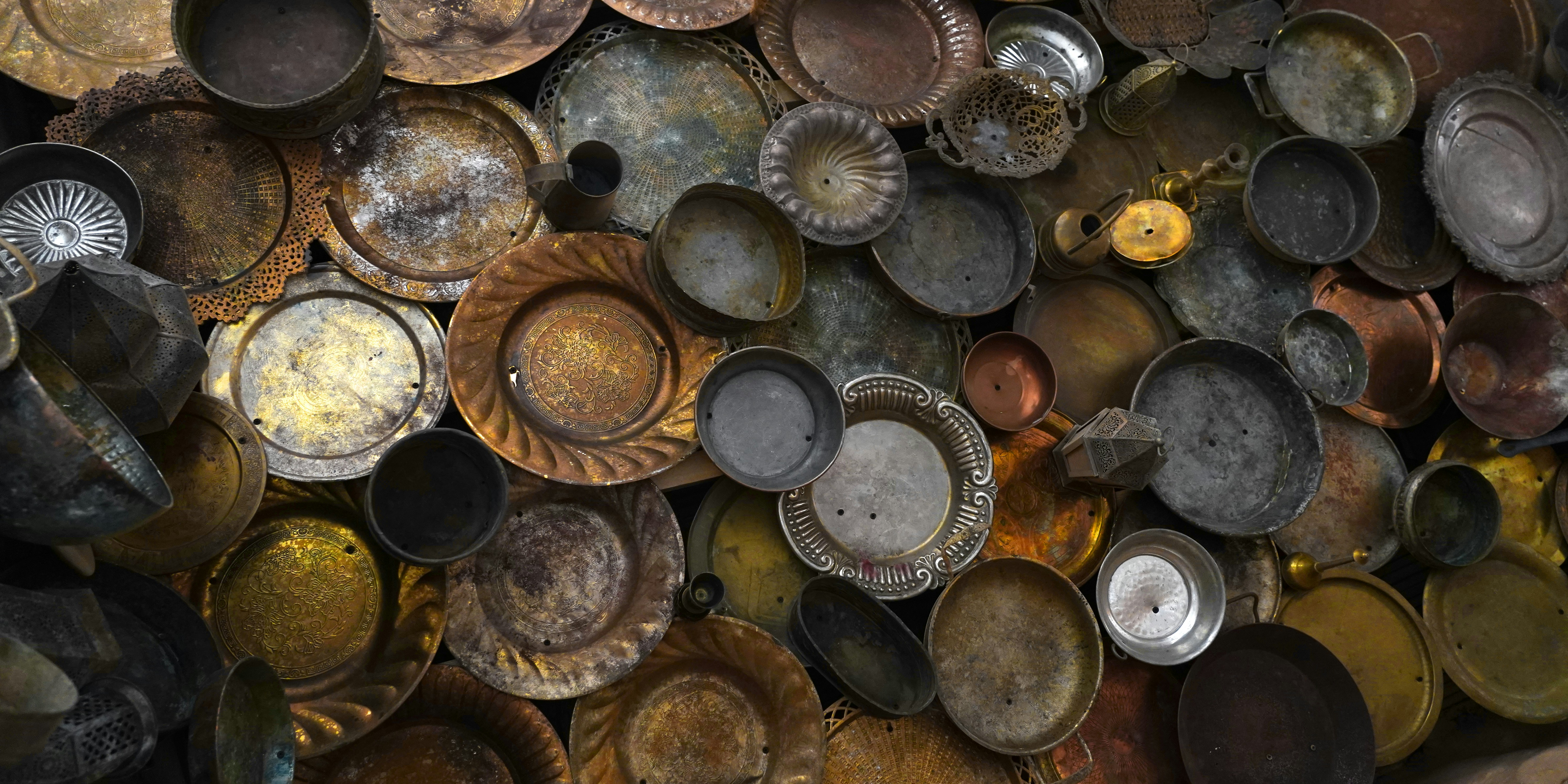 A pile of metal plates and pans sitting on top of each other