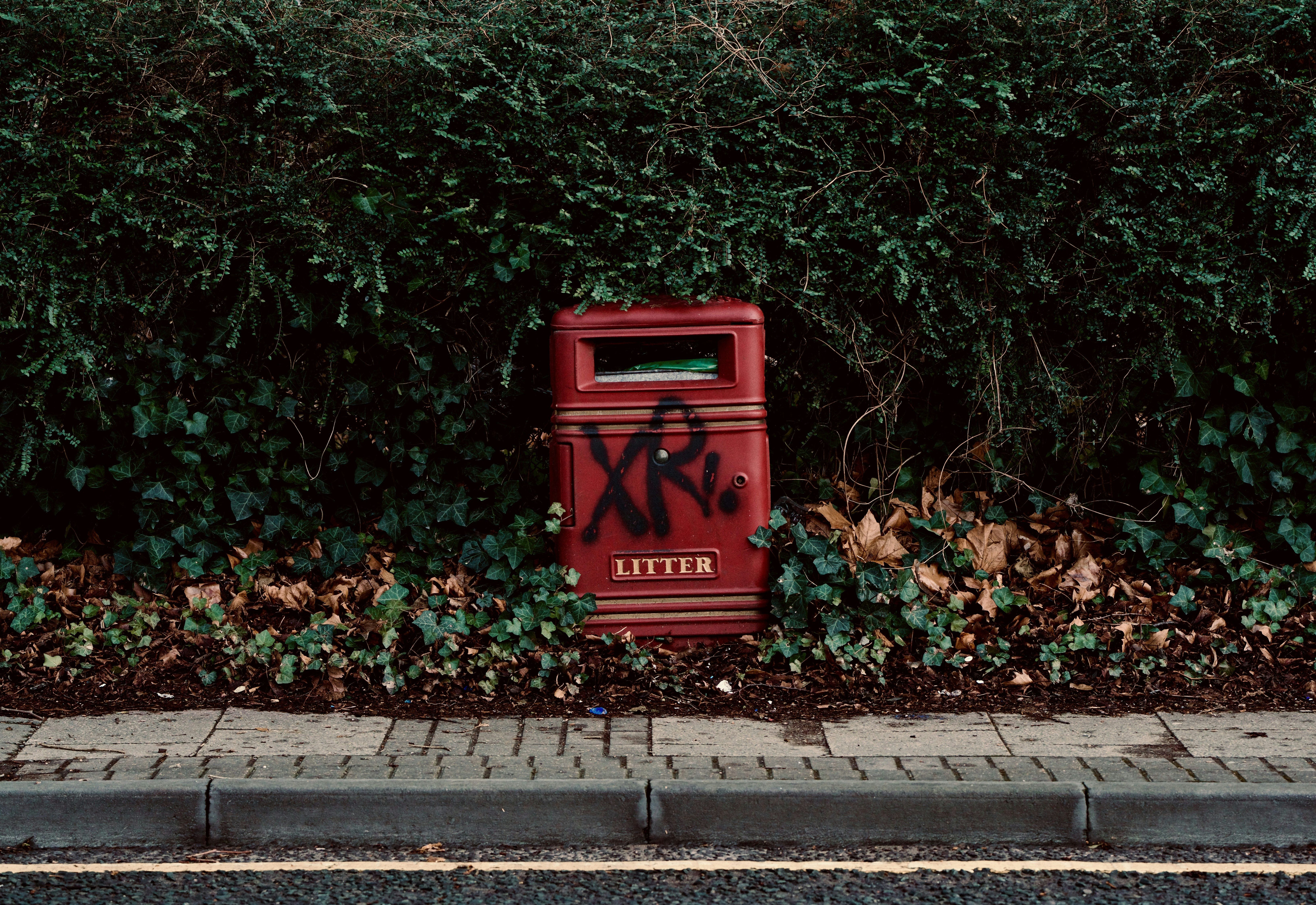A red mailbox sitting on the side of a road
