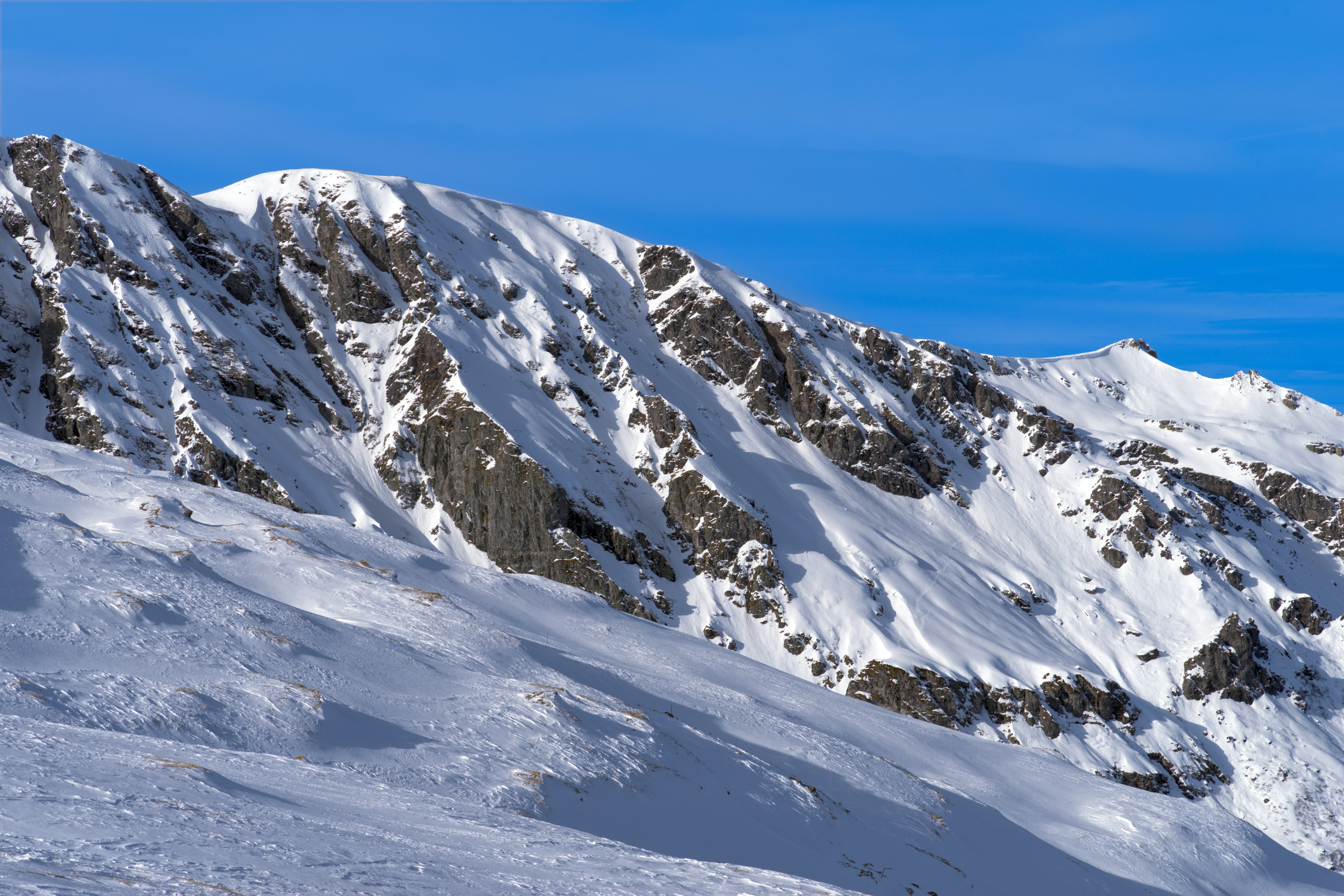 A man riding skis down the side of a snow covered slope