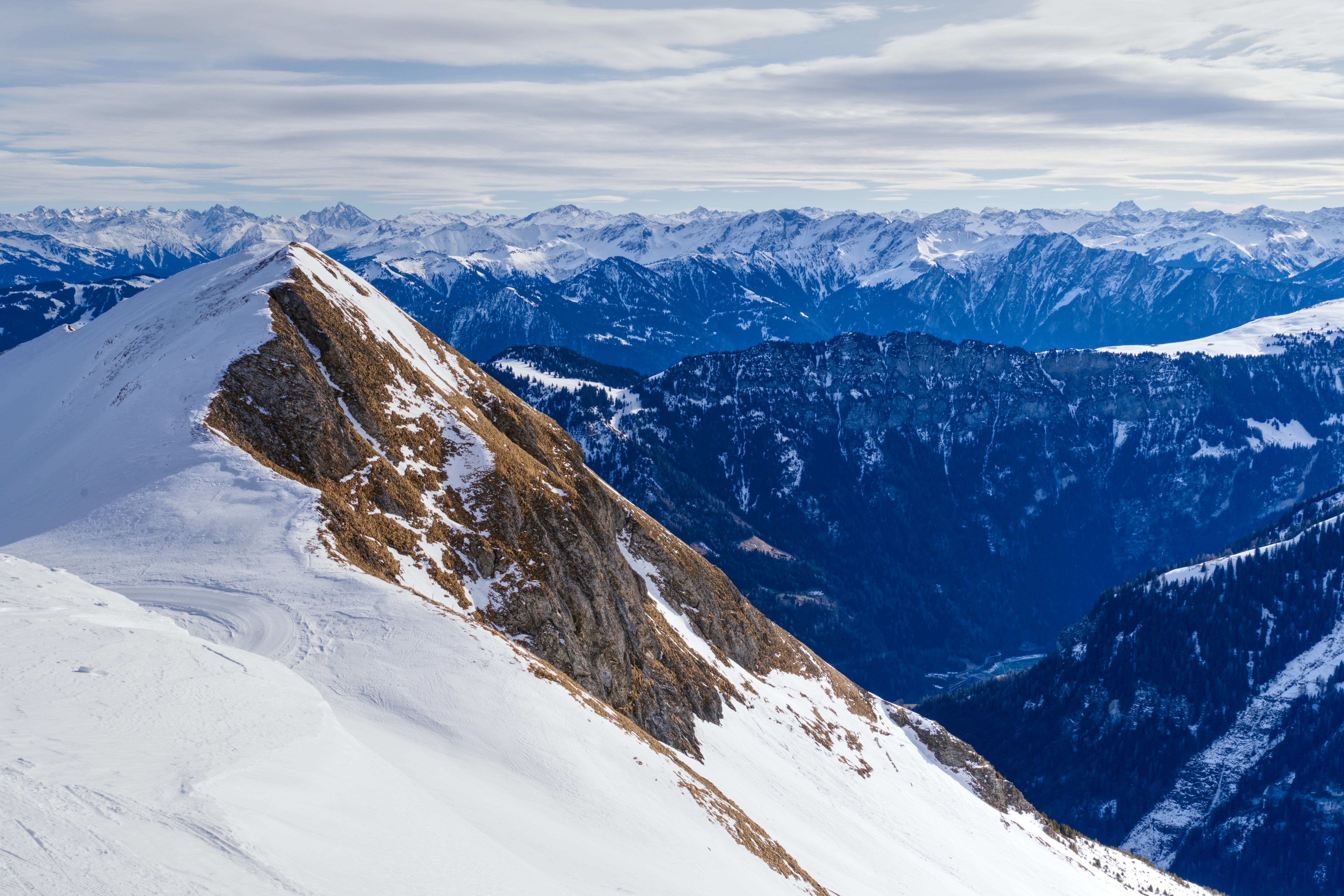 A person standing on top of a snow covered mountain