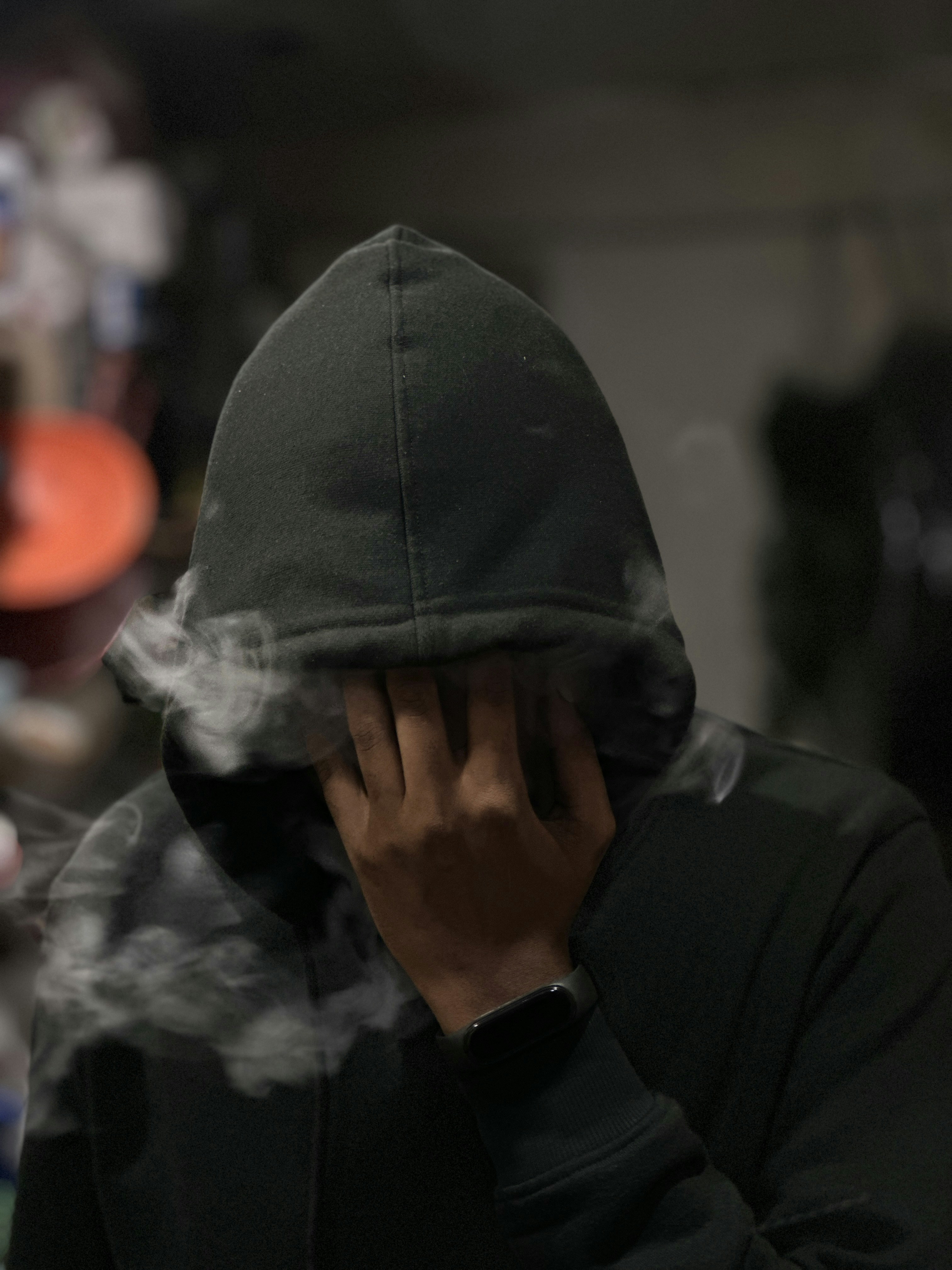 パーカーを着てタバコを吸う男